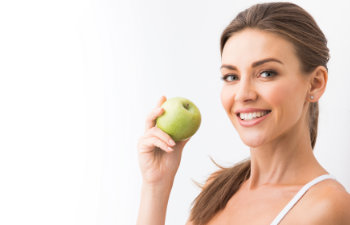 attractive woman holding an apple and smiling, 